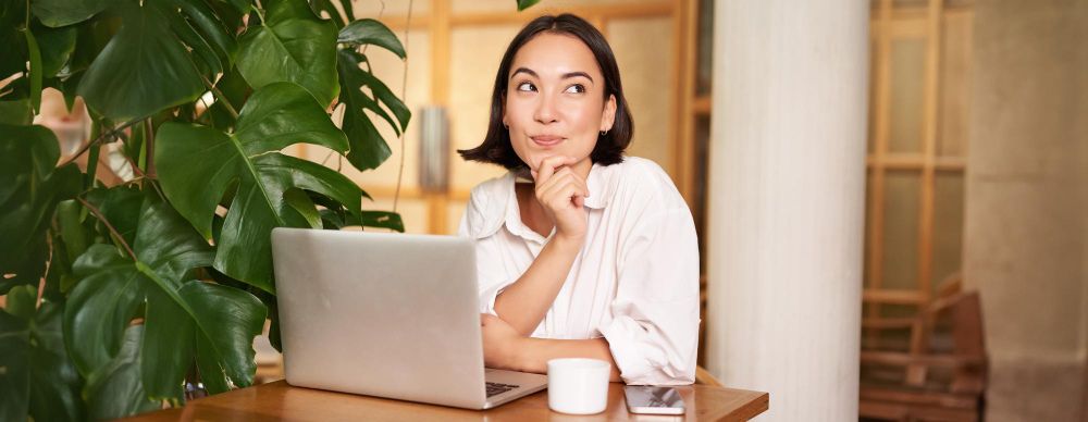 A woman in front of the laptop thinking about Spain Expat FAQ